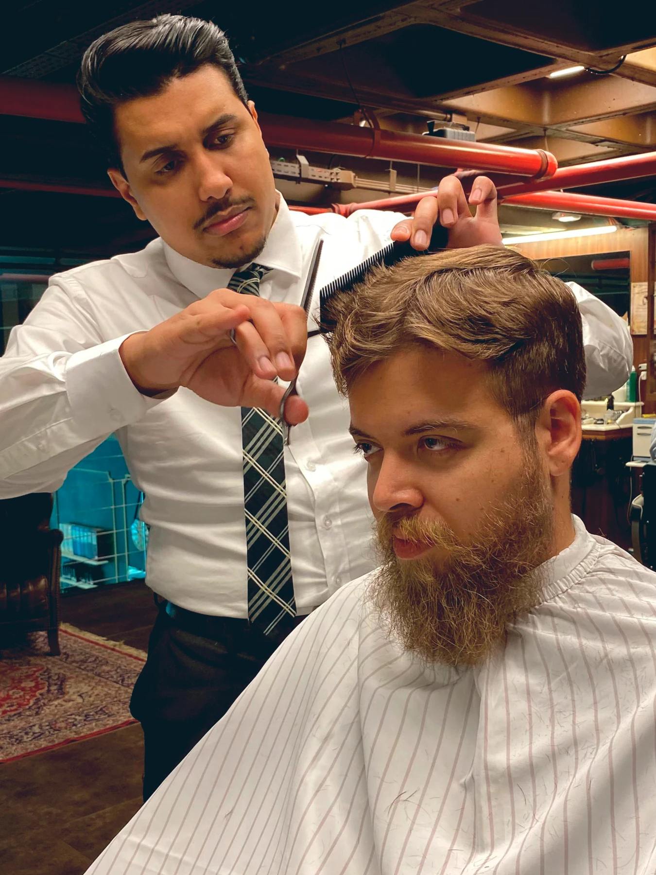Jonathan Nascimento concentrado em um corte masculino